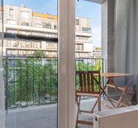 Blick aus einer Einzimmerwohnung auf den Balkon mit Tisch und Stühlen.