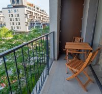 Balkon einer Einzimmerwohnung in der Zuzany-Chalupovej-Straße, Bratislava - Petržalka mit Holzmöbeln.