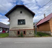 Ein Einfamilienhaus in Stankovany mit einem Steinsockel und einer einfachen weißen Fassade.