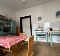Eine Küche in einem Einfamilienhaus mit Retro-Möbeln und einem Boden in Holzoptik.