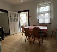 Eine Küche in einem Einfamilienhaus mit einem Holztisch, einem Regal und einem Boden mit Holzdekor.