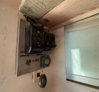 Alter elektrischer Verteilerkasten in der Garage, mit alten Sicherungen und Steckdosen.