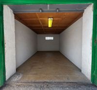 Offene Garage mit Holzdecke und Betonboden.