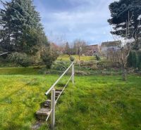 Garten eines Einfamilienhauses in der Makovického-Straße in Ružomberok mit Rasen und Bäumen.