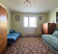 Ein Zimmer in einem Einfamilienhaus mit Möbeln im Retro-Stil und einem Teppich mit Dekor.