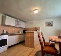 Küche in einem Einfamilienhaus mit Esstisch, Ofen und Kühlschrank.