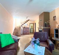 Wohnzimmer in einem Einfamilienhaus mit Holzboden, Kamin und Treppe.