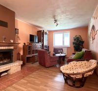 Wohnzimmer mit Kamin, Sitzgarnitur und Holzboden in einem Einfamilienhaus.