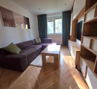 Wohnzimmer in einer 2-Zimmer-Wohnung mit einem bequemen Sofa und einem Holzboden.
