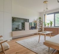 Wohnzimmer mit Holzboden, Sofa und Zimmerpflanzen in einer Zweizimmerwohnung.