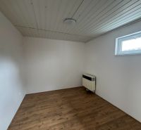 Ein Zimmer mit Holzboden und weißen Wänden in einer 2-Zimmer-Wohnung.