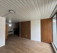 2-Zimmer-Wohnung mit Holzboden und Holzverkleidung an der Wand.