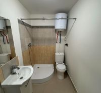 Badezimmer in einer 2-Zimmer-Wohnung mit Badewanne, Waschbecken und Toilette, helle Wandfliesen.