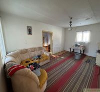 Wohnzimmer in einem Einfamilienhaus mit Kachelofen, Teppich und Sofa ohne Holzdekor.