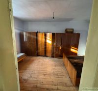 Ein Zimmer in einem Einfamilienhaus mit Holzmöbeln und einem Bett auf dem Boden mit Holzdekor.