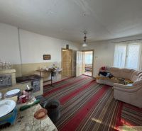 Wohnzimmer in einem Einfamilienhaus mit Teppichen, Kamin und Sofa.