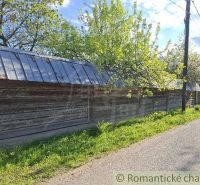 Ein Holzzaun bei einem Einfamilienhaus in Šumiac, umgeben von Bäumen und einer Straße.