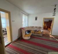 Ein Einfamilienhaus mit Teppich, beigem Sofa, Türen und einem Bild an der Wand.