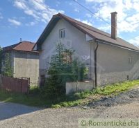 Ein Einfamilienhaus in Šumiac mit einem Blechdach und einem Garten an der Straße.