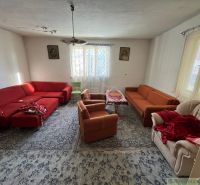 Wohnzimmer in einem Einfamilienhaus mit roten und orangenen Sofas und einem Teppich.