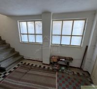 Innenraum eines Einfamilienhauses mit Treppe, Teppich und großen Fenstern.