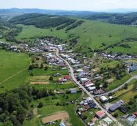 Luftaufnahme des Dorfes Karná, umgeben von Hügeln und Wohngebieten.