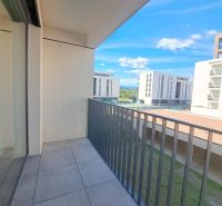 Balkon in einer 2-Zimmer-Wohnung in Poprad mit Blick auf moderne Gebäude und Grünflächen.