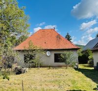 Einfamilienhaus in Pažiti mit rotem Dach auf einem gepflegten Garten.