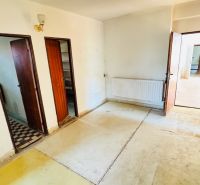 Innenraum mit altem Boden, Holztüren und Heizkörper in einem Einfamilienhaus.