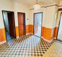 Flur im Einfamilienhaus mit Fliesen und Holzelementen an den Wänden.