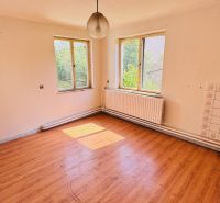 Ein geräumiges Zimmer mit Holzboden in einem Einfamilienhaus.