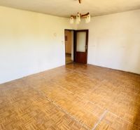 Ein Zimmer in einem Einfamilienhaus mit einem Boden in Holzoptik und einem Kronleuchter.