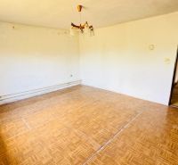 Wohnzimmer in einem Einfamilienhaus mit Holzboden und einfacher Beleuchtung.