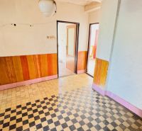 Innenraum eines Einfamilienhauses mit Fliesenboden und Holzdekor an den Wänden.