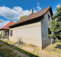 Ein Einfamilienhaus in Pažiť, umgeben von Grün, mit einem roten Dach und Holzfenstern.