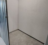 Kleine Lagerräume mit Metalltüren und Betonboden in einer Zweizimmerwohnung.