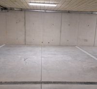 Unterirdische Garage mit Betonboden und Beleuchtung.