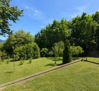 Garten mit Rasen und Bäumen in Považská Bystrica in der Straße Klučina bei der Hütte.