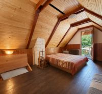 Das Innere der Hütte mit Holzverkleidung und Boden in Holzoptik, sichtbares Bett und Eingang.