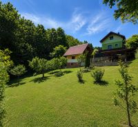 Hütte auf Klučina in Považská Bystrica mit gepflegtem Garten, Bäumen und grünem Gras.