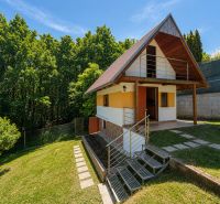 Eine Hütte mit Holzelementen in Považská Bystrica auf Klučina, umgeben von Grün und Bäumen.