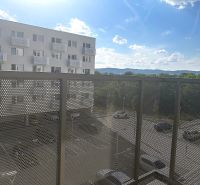Balkon in einer Einzimmerwohnung mit Blick auf den Parkplatz und die umliegenden Berge.
