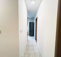 Ein Flur mit Fliesen, der zu den Zimmern in einer 2-Zimmer-Wohnung führt.