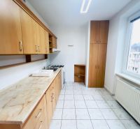 Küche mit Holzdekor und weißen Fliesen in einer 2-Zimmer-Wohnung.