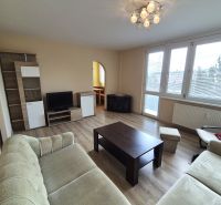 Wohnzimmer in einer 4-Zimmer-Wohnung mit Holzboden, hellem Möbeln und Sitzgarnitur.