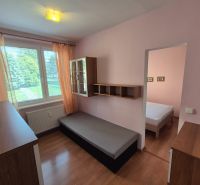 Ein Zimmer mit einem Bett, Schränken und einem Boden in Holzoptik in einer Vierzimmerwohnung.