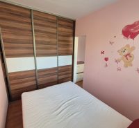 Schlafzimmer in einer 4-Zimmer-Wohnung mit Holzboden und einer Wandaufkleber von einem Bären.