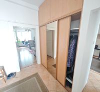 Einbauschrank und Fliesen im Flur einer 2-Zimmer-Wohnung mit Holzboden-Dekor.