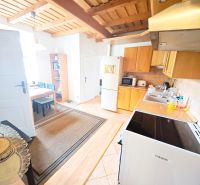 Küche in einer 2-Zimmer-Wohnung mit Holzboden und Holzdecke.