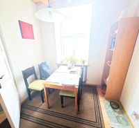 Jedálenský kút so stolom, stoličkami a policami v 2-izbovom byte.

Essbereich mit Tisch, Stühlen und Regalen in einer 2-Zimmer-Wohnung.